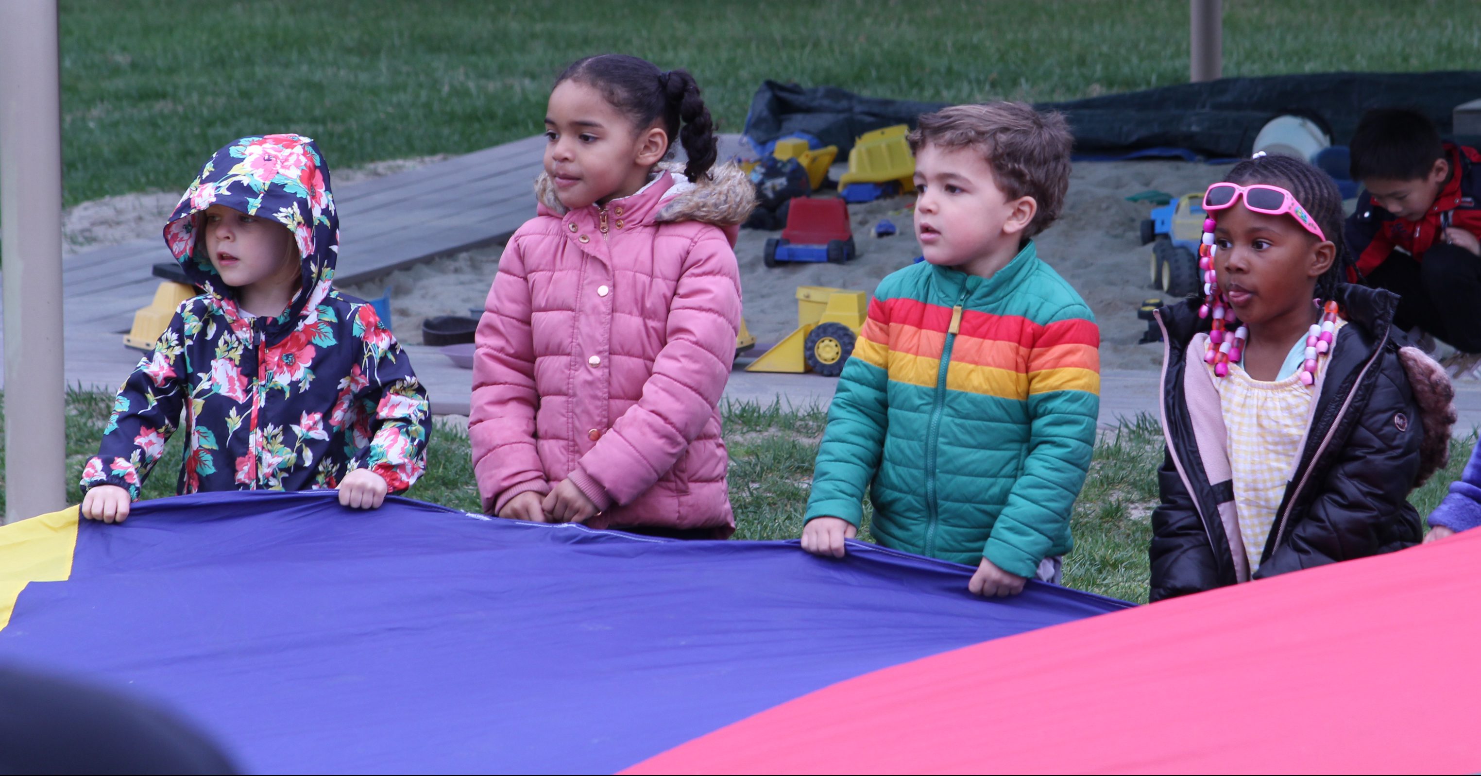 Child sitting on bench with toys