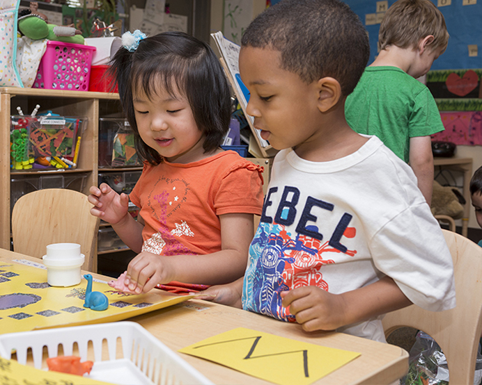 Two young children painting at the Early Learning Center