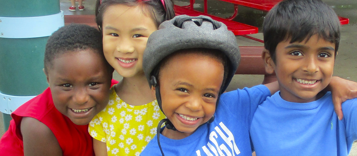 Four smiling school-aged child at the Early Learning Center