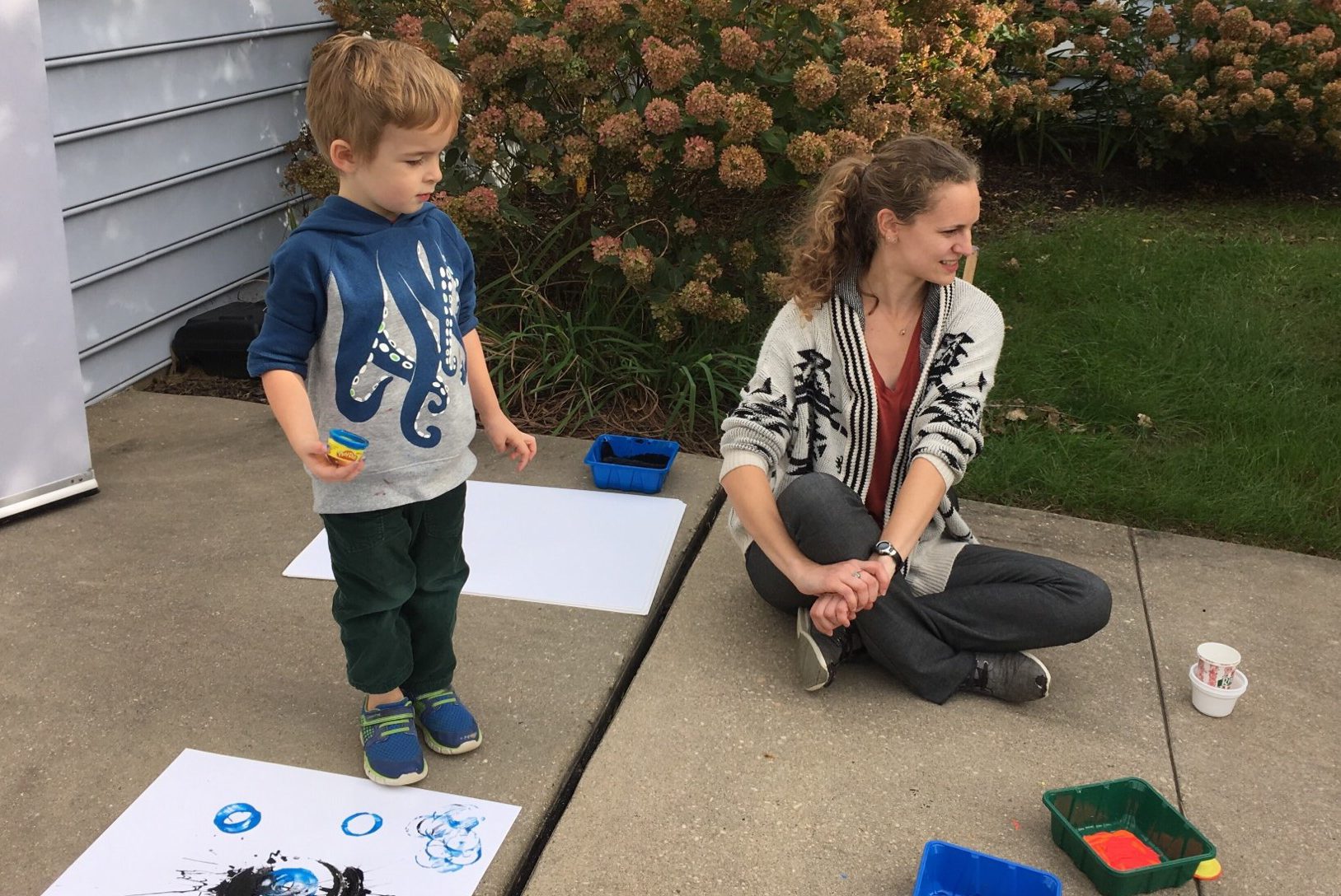 child and teacher outside painting