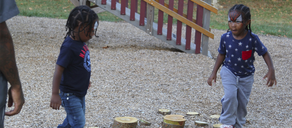 Two children outside at the University of Delaware Early Learning Center