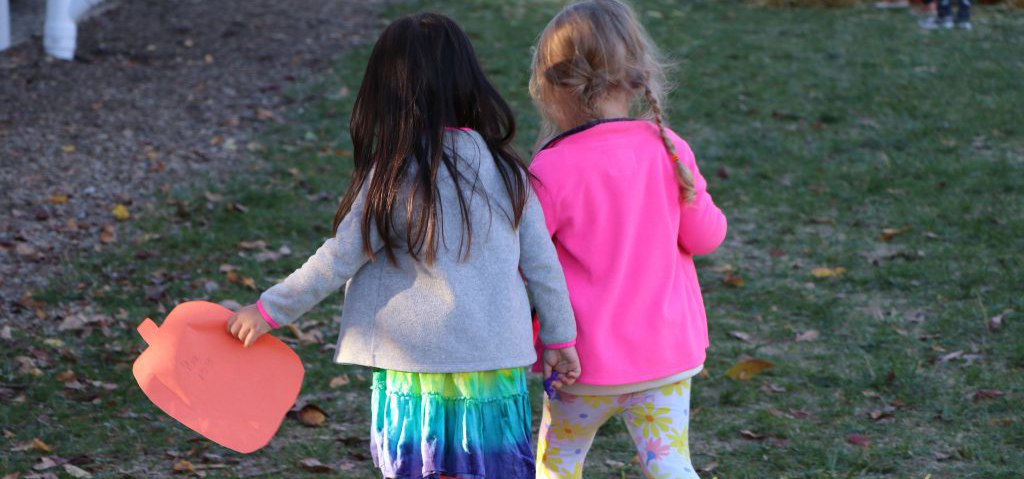 Two girls hold hands at the Early Learning Center