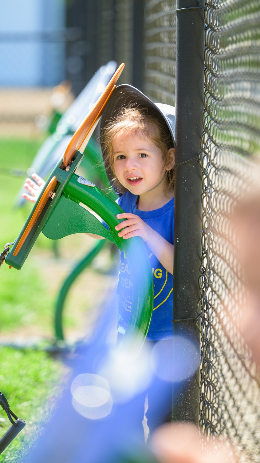 Child sitting on bench with toys